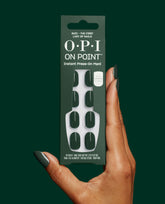 Hand holds OPI On Point Suzi - The First Lady of Nails instant press-on mani box with glossy deep green artificial nails, matching manicure, and up to 14 days of wear on a dark green background.