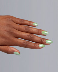 Manicured hand showcases Taurus-t Me Dipping Powder, a shimmery mint green nail polish by OPI, with glossy oval tips, highlighting fresh spring nail colors against a clean gray studio background.