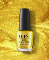 OPI nail polish bottle of The Leo-nly One yellow nail lacquer standing upright against a swirling metallic gold glitter backdrop, showcasing the bold, shimmery shade for vibrant manicures in the US market.