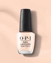 OPI Throw Me a Wink nail lacquer bottle in a soft pale peach shade with a black cap, shown upright on a peach background for fall nail colors.