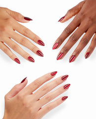 Hands with varied skin tones showcase OPI Undercover Waitress xPRESS/ON nails, a glossy deep red chrome almond manicure ideal for bold fall nail colors on a clean white background.