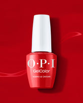 OPI GelColor Vodka & Caviar red gel nail polish bottle stands upright with a white cap against a glossy red background, showcasing a classic shade for fall nail colors.