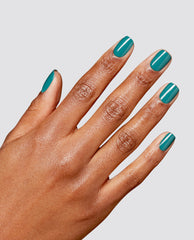 Hand with medium-brown skin tone shows neatly manicured nails painted in glossy teal from the What a Winterful World OPI RapiDry nail polish gift set against a clean light gray background.