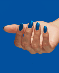 Hand with medium-length oval nails showcases Y2Slay nail lacquer, a vivid metallic blue OPI nail polish, against a solid cobalt blue background, highlighting the glossy, full-coverage manicure finish for bold modern nail looks.