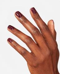 Hand with neatly manicured nails showcases OPI nail polish shade Yes, My Condor Can-do!, a glossy deep plum nail lacquer, against a clean white background highlighting the rich color and smooth finish.
