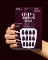 OPI xPRESS/ON You Don’t Know Malaga press-on nails in deep burgundy are shown on a manicured hand holding the matching package, highlighting glossy extra-short fall nail colors.