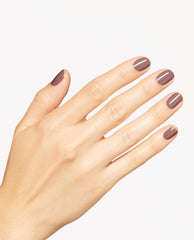 Hand modeling OPI You Don’t Know Suzi nail lacquer, a glossy taupe-brown shade on short rounded nails against a clean white background.