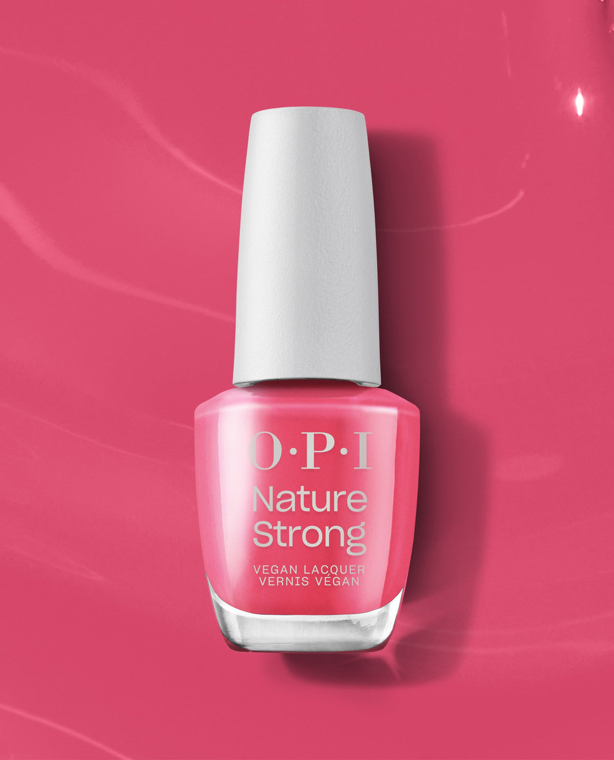 OPI Nature Strong “A Kick in the Bud” vegan nail lacquer bottle displays a bright pink polish, standing upright on a matching glossy backdrop, a fresh pick for spring nail colors and spring nail trends from OPI.