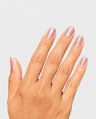 Hand displaying a fresh manicure in OPI Flash n’ Flirty RapiDry nail polish, with short oval nails coated in a shimmery pale pink-lavender finish against a clean light gray background, highlighting the nail polish gift set result.