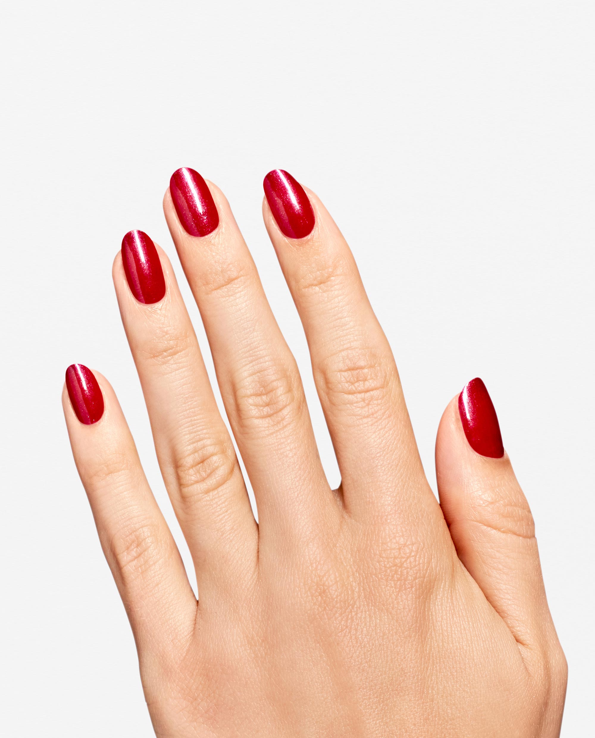 Hand displays glossy red shimmer manicure using OPI RapiDry Ring the Alarm, a bold shade for fall nail colors, on short rounded nails against a clean white background.