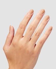 Hand with neatly manicured nails painted in A Total Suzi Infinite Shine, a glossy beige nude OPI nail polish, shown against a light gray background to highlight the smooth, even coverage and natural everyday shade.