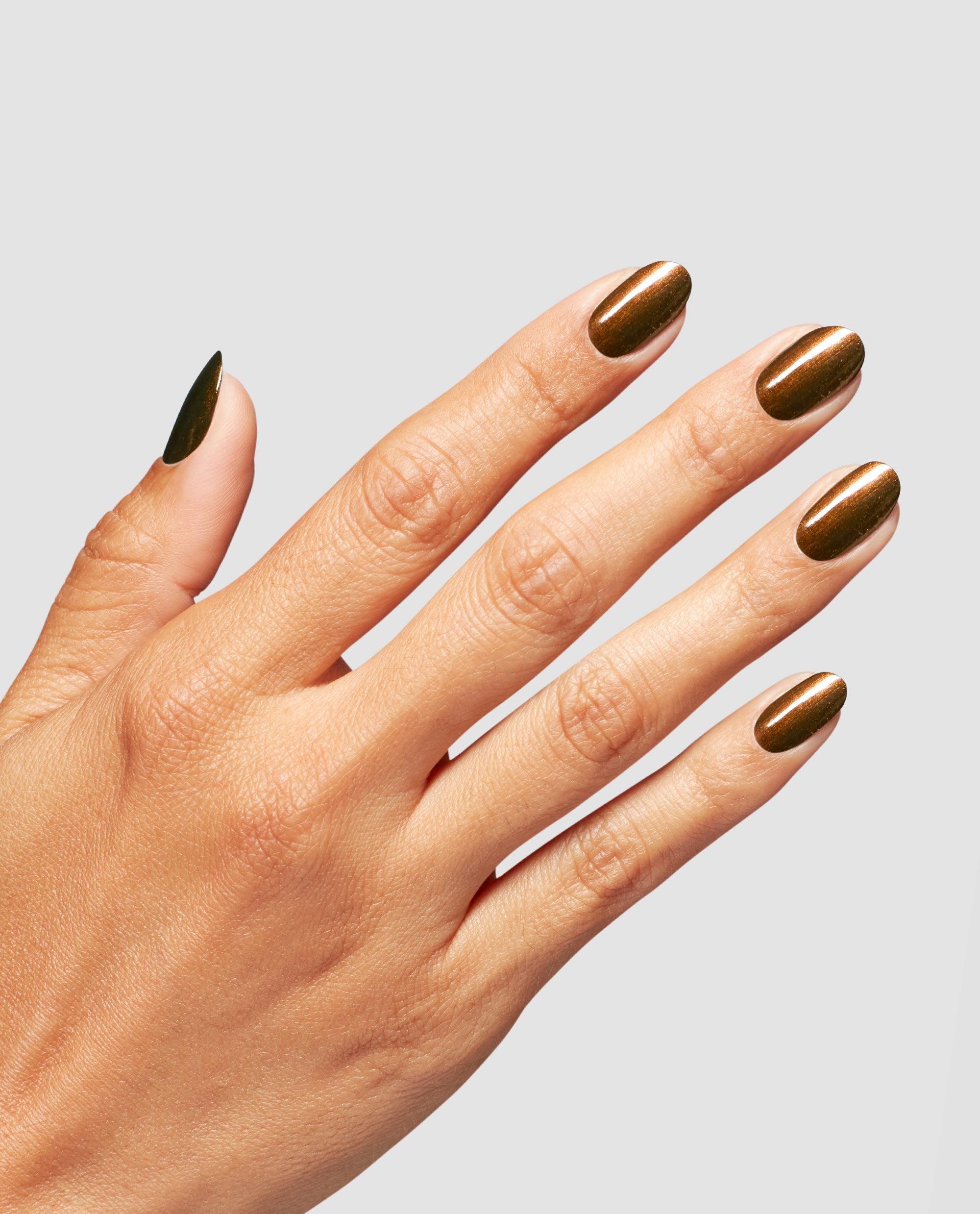 Hand modeling Band Tease nail lacquer, a shimmering metallic bronze OPI nail polish with a reflective stripe effect on oval-shaped nails against a clean light gray background.