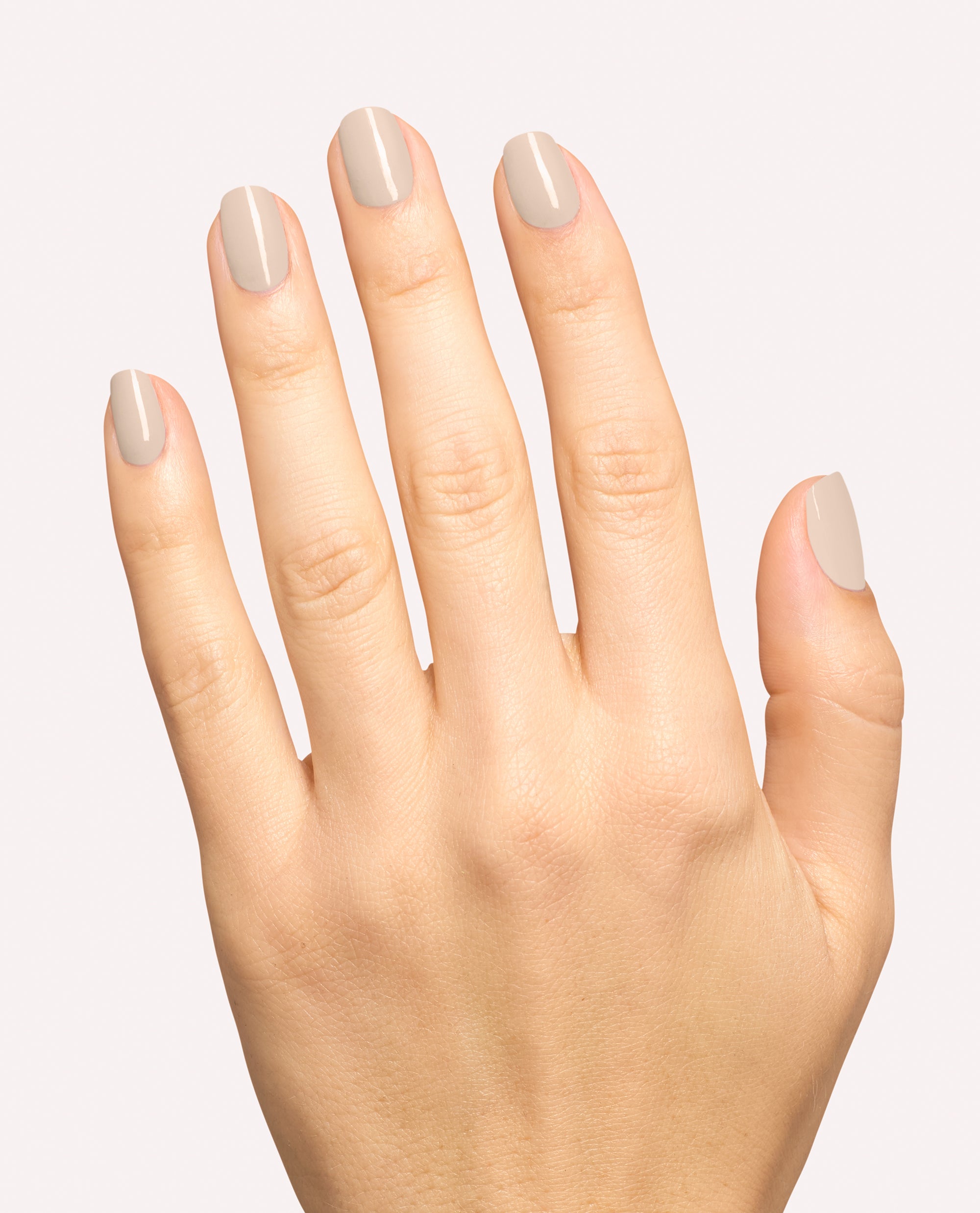 Hand modeling glossy taupe-gray nails using OPI Berlin There, Doin’ That dipping powder, a neutral shade for fall nail colors, against a clean light background.
