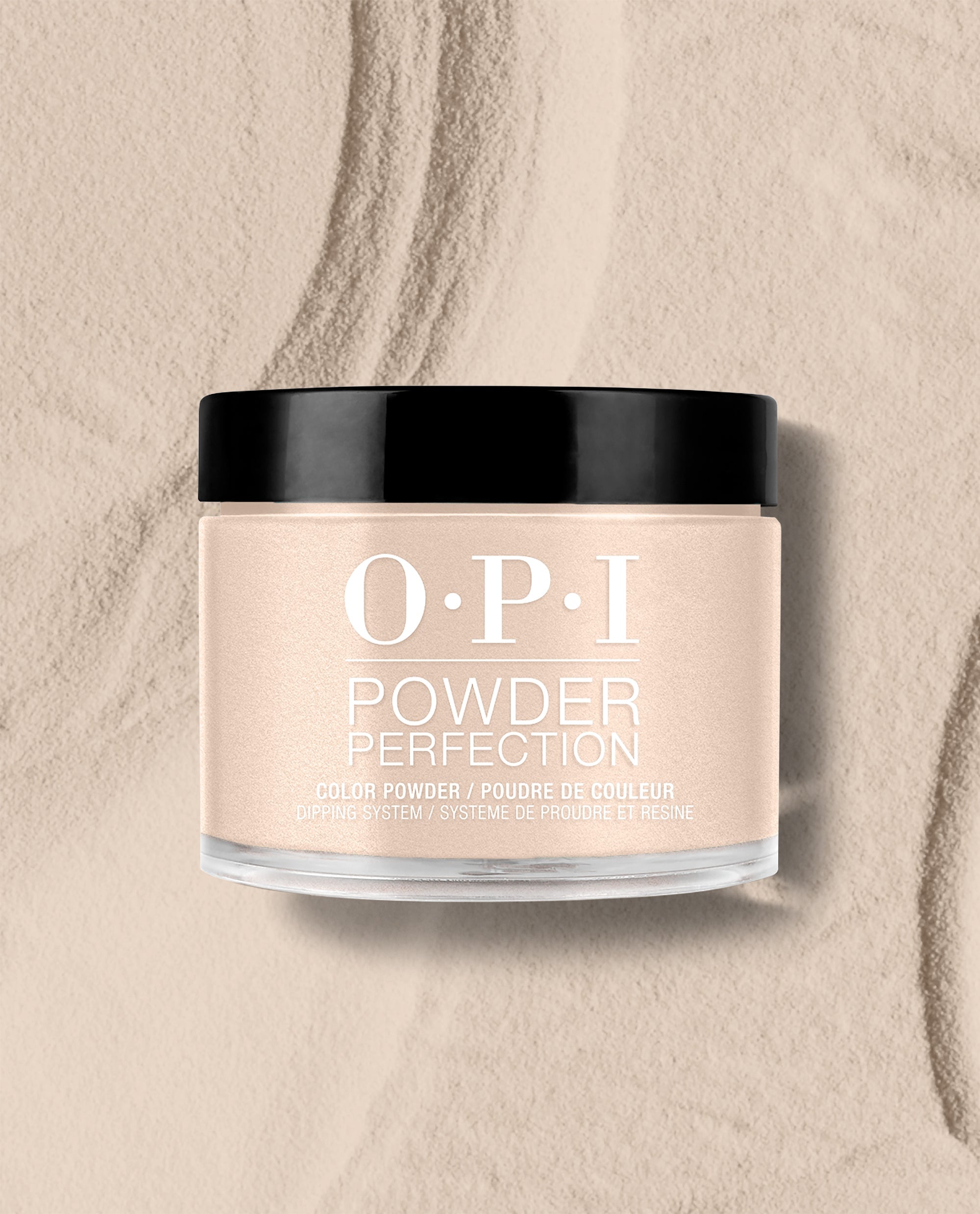 OPI Powder Perfection Berlin There, Doin’ That dipping powder jar sits on a textured beige powder surface, showing a soft taupe shade for fall nail colors.