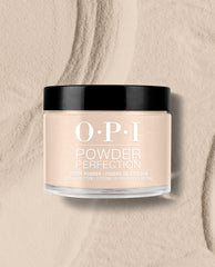 OPI Powder Perfection Berlin There, Doin’ That dipping powder jar sits on a textured beige powder surface, showing a soft taupe shade for fall nail colors.