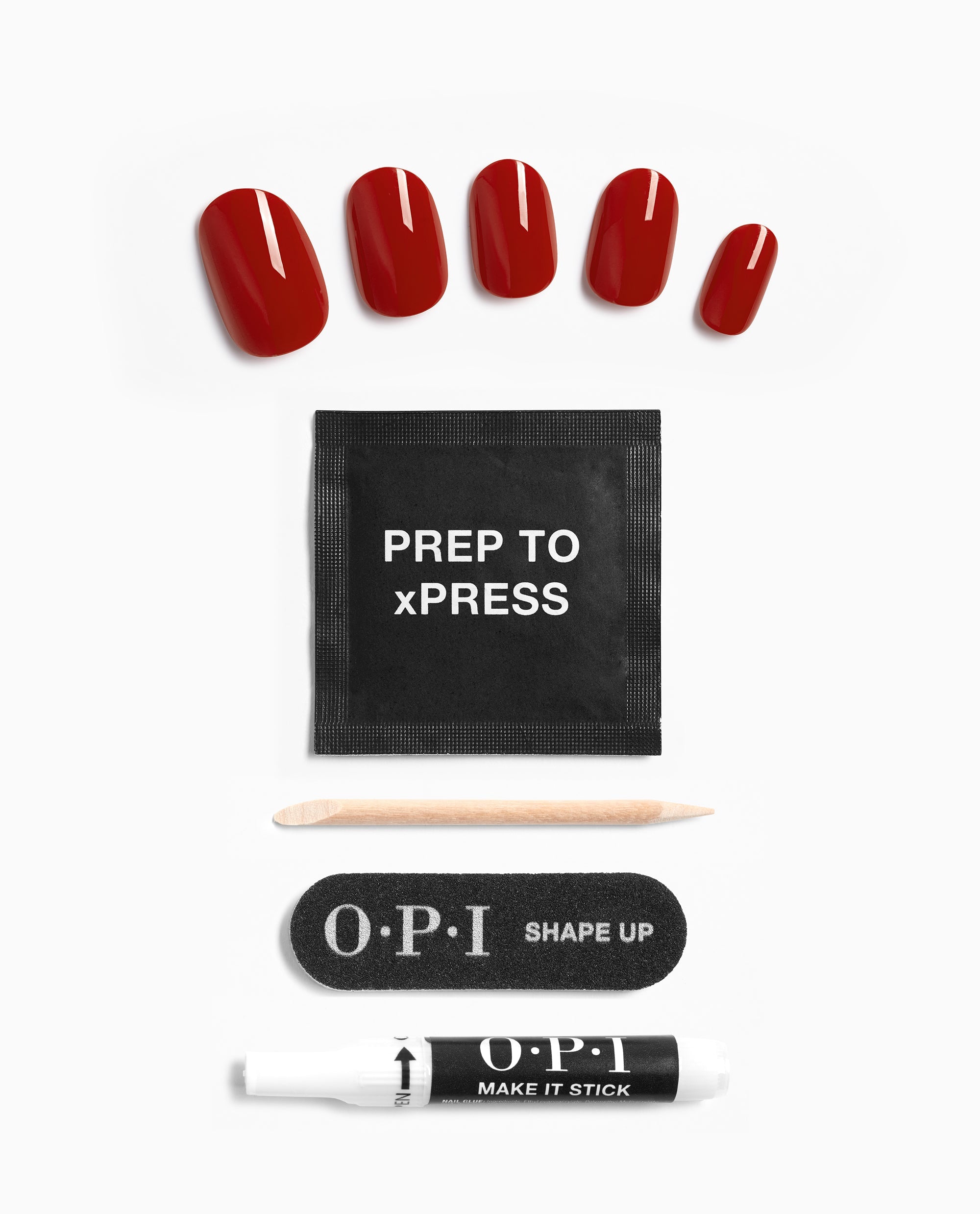 OPI Big Apple Red xPRESS/ON press-on nail kit displays glossy red artificial nails with a prep pad, wooden cuticle stick, black Shape Up nail file, and Make It Stick glue on a white background.