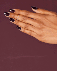Hand modeling glossy OPI Black Cherry Chutney nail lacquer, a deep black cherry shade for fall nail colors, against a rich burgundy background.