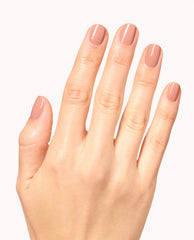 Hand displays glossy mauve-nude OPI Infinite Shine Boots in Barcelona manicure on short rounded nails, a soft neutral choice for fall nail colors on a white background.