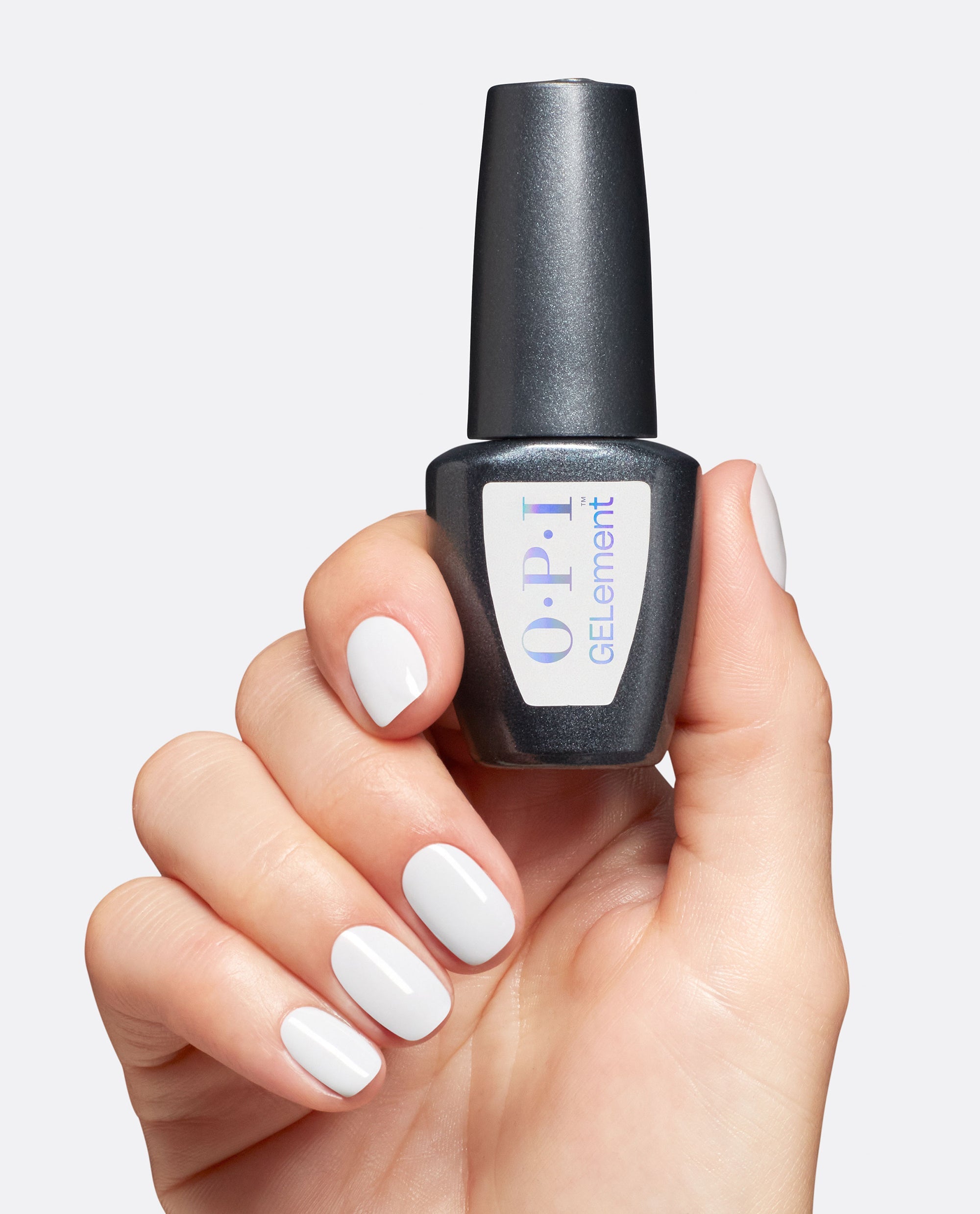 Hand with glossy white gel manicure holds an OPI GelColor bottle for BRB, Doing My Nails, a trending at-home gel nail polish shade on a clean light gray background.