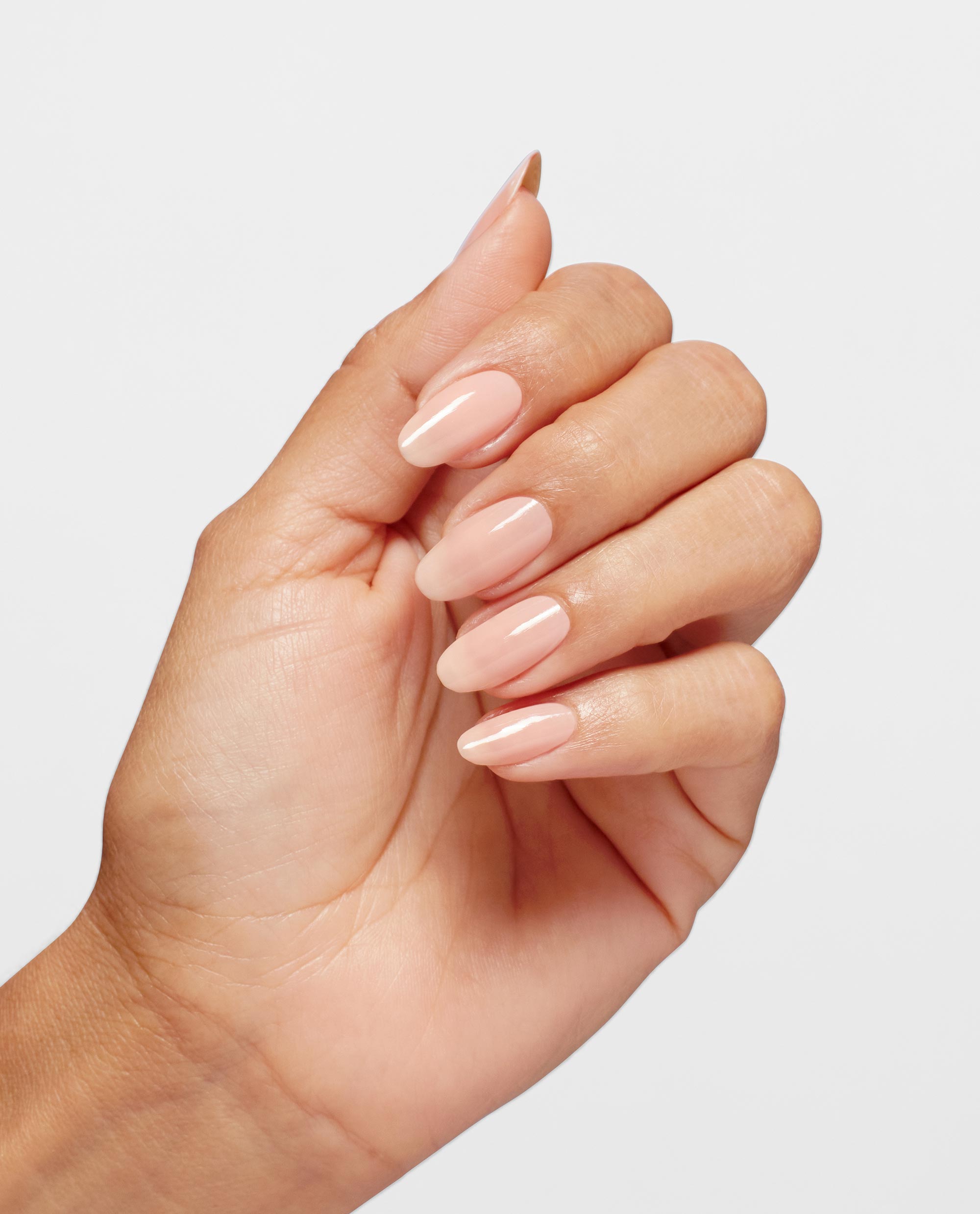 Hand with medium skin tone showing glossy, almond-shaped nails painted in OPI Bubble Bath Infinite Shine, a soft sheer pink shade, against a clean white background, ideal for promoting an OPI nail polish gift set in the US market.