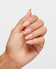 Hand with medium skin tone showing glossy, almond-shaped nails painted in OPI Bubble Bath Infinite Shine, a soft sheer pink shade, against a clean white background, ideal for promoting an OPI nail polish gift set in the US market.