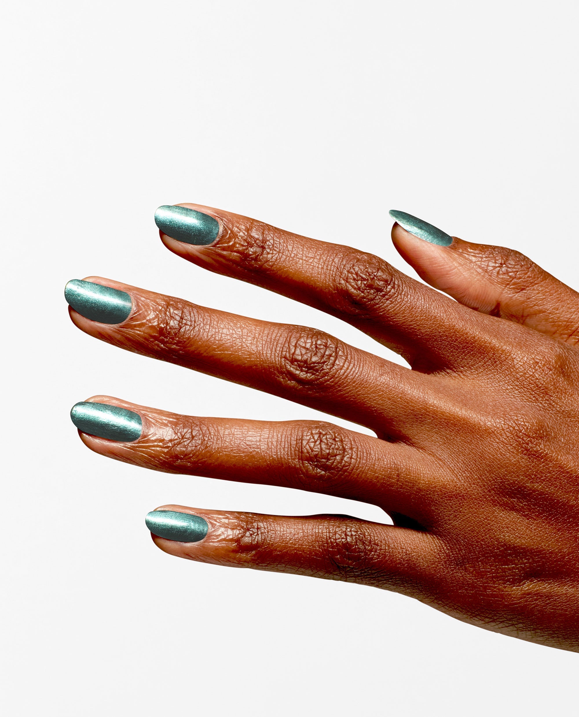 Hand displays metallic teal green nail polish, OPI Infinite Shine Cos-mo Money, with a glossy shimmer on neatly filed nails, showcasing spring nail colors against a clean white background.