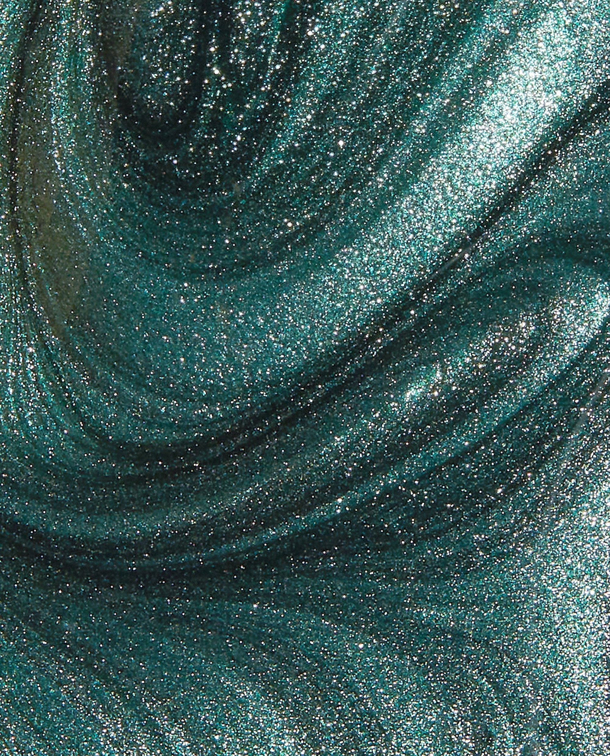 Metallic emerald green nail polish swatch sparkles and swirls in a macro view, showcasing OPI Infinite Shine Cos-mo Money's high-shine shimmer, ideal for spring nail colors; green nail polish by OPI.