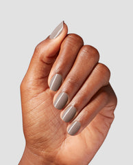 Hand shows short, neatly manicured nails painted with Crimp and Proper, a glossy taupe-beige OPI nail polish nail lacquer, against a light gray background, highlighting smooth, even coverage and salon-quality finish for US shoppers.