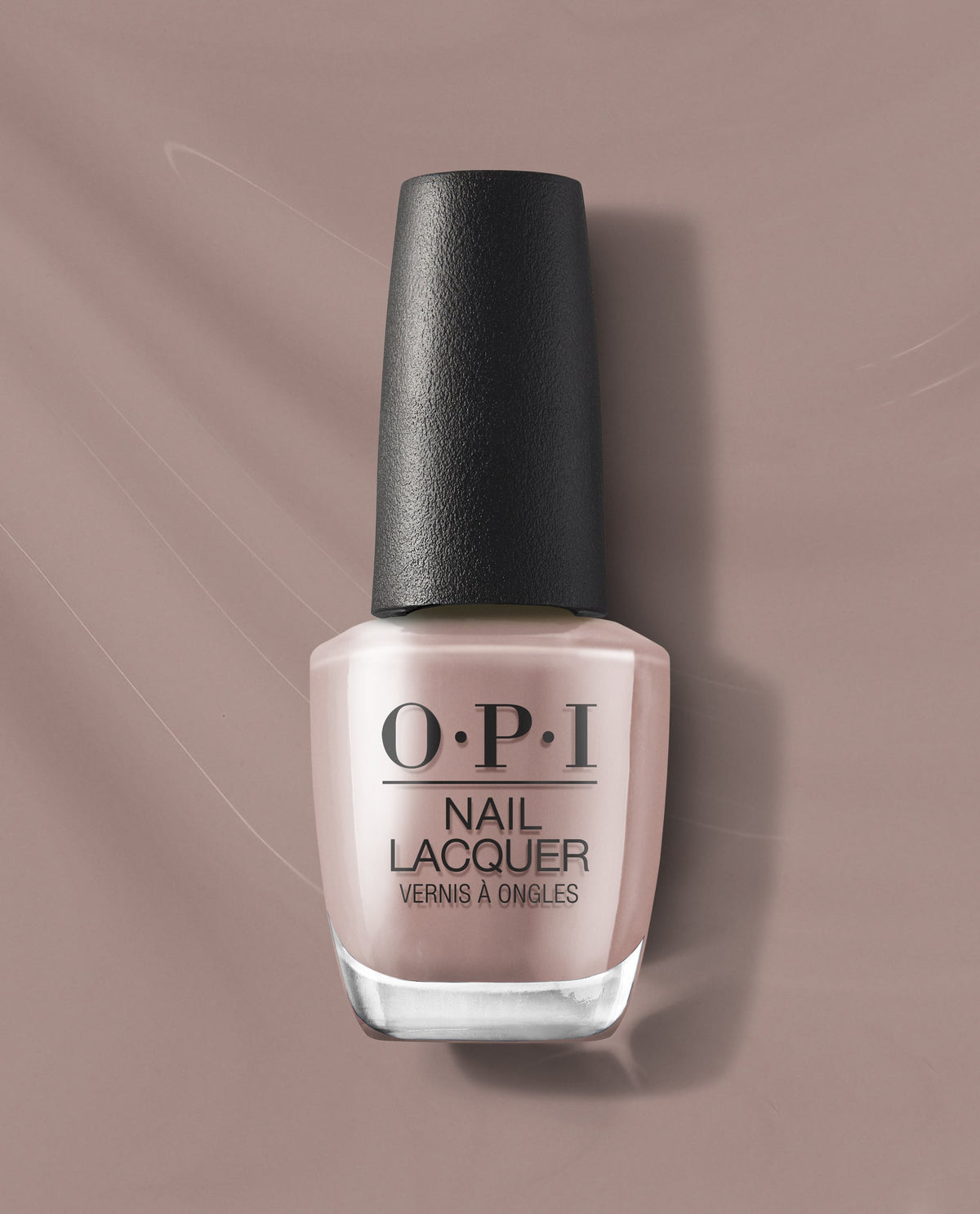 OPI nail polish bottle of Crimp and Proper nail lacquer standing upright, showcasing a soft nude-beige shade with black textured cap, centered on a matching taupe background for a clean, modern product display.