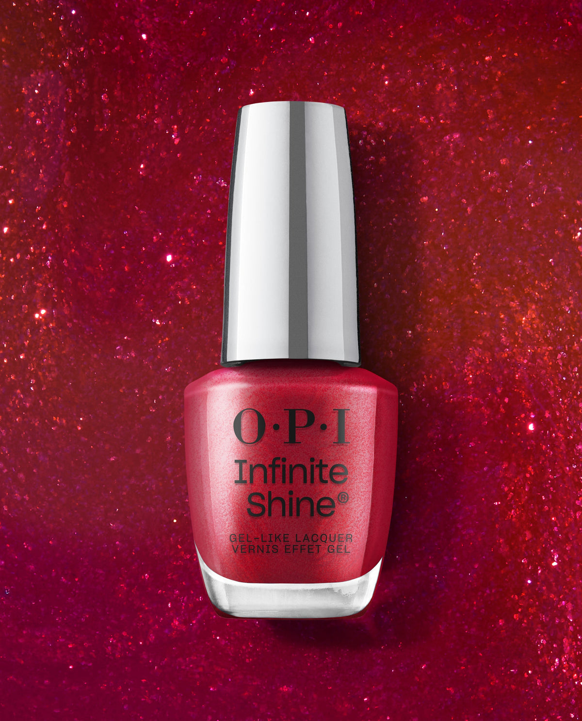OPI Infinite Shine Deer Valley Spice red shimmer gel-like lacquer bottle stands centered on a sparkling red glitter background, showcasing bold fall nail colors.