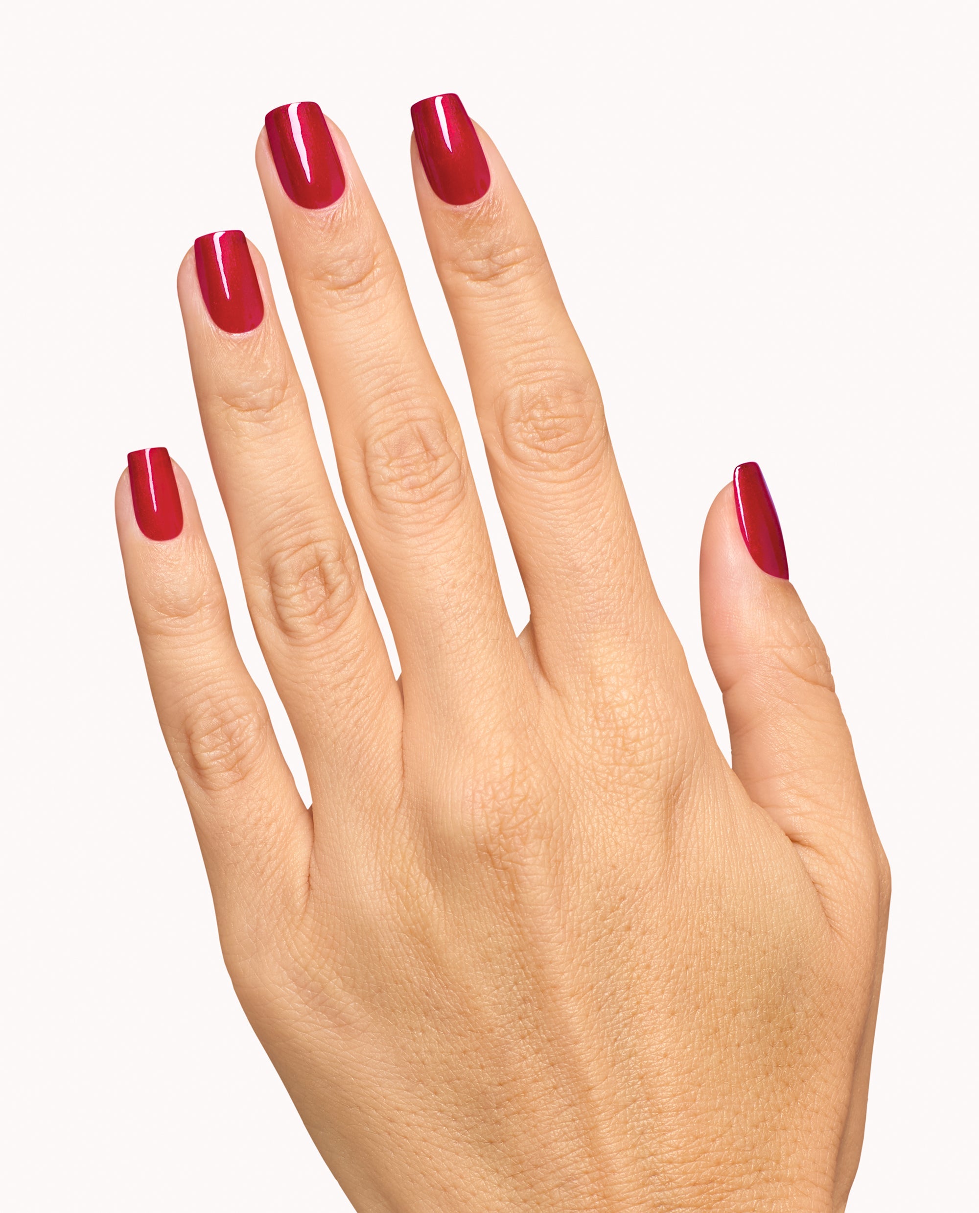 Hand displays glossy deep red manicure with OPI Infinite Shine Deer Valley Spice, a rich shade for fall nail colors, on a clean white background.