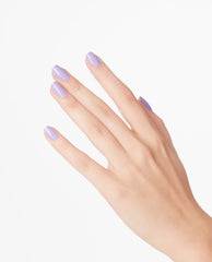 Hand with neatly manicured nails painted in OPI nail polish shade “Don’t Toot My Flute,” showing a glossy pastel lavender nail lacquer against a clean white background for a modern, minimalist beauty product look.
