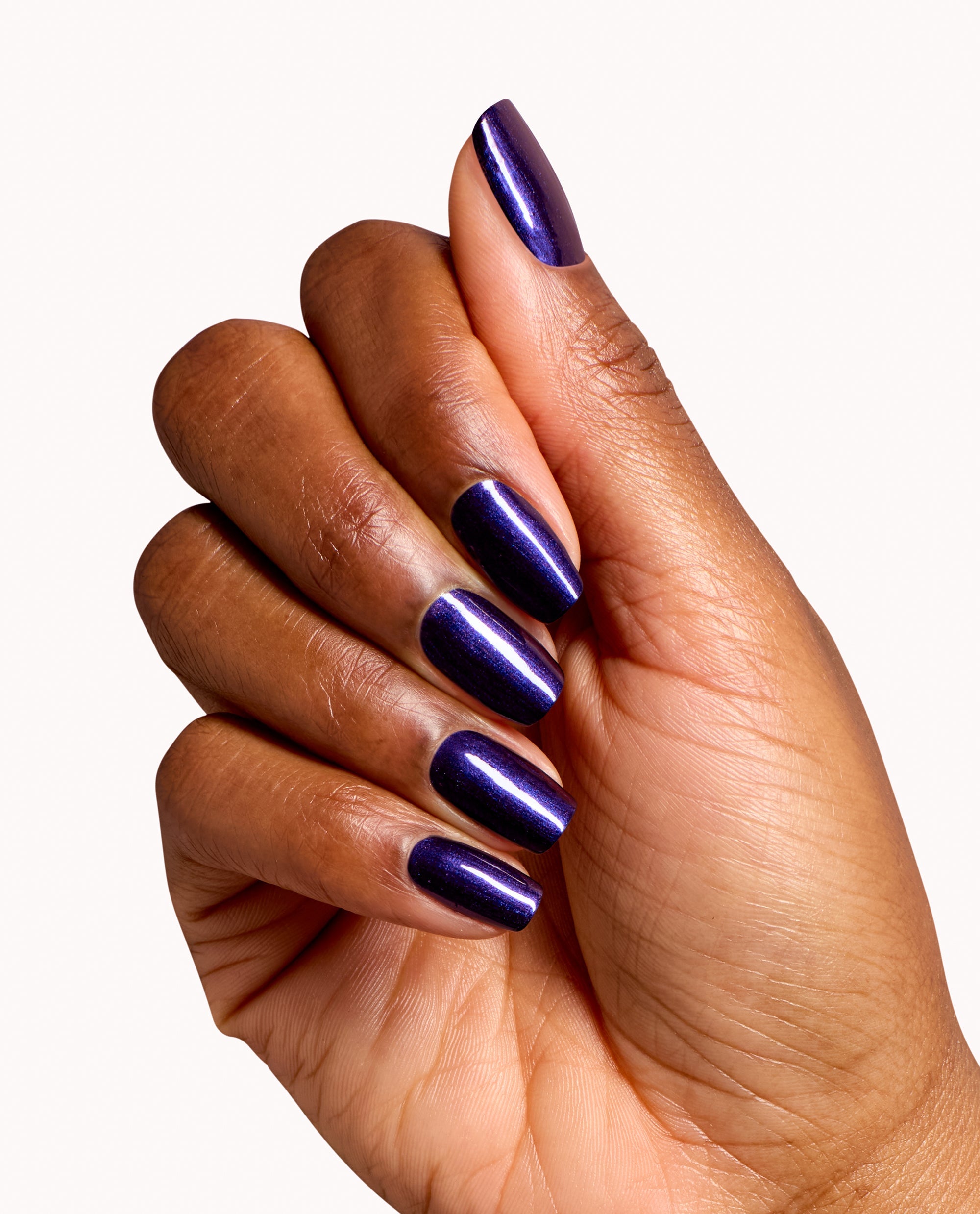Hand showing glossy deep purple shimmer manicure using OPI Don't Over Ink It dipping powder, a bold choice among fall nail colors, on long square nails against a white background.