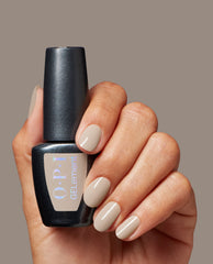 Hand with glossy taupe-beige manicure holds an OPI GelColor bottle in Espresso Martini Please, an at-home gel nail polish shade for chic fall nail colors.