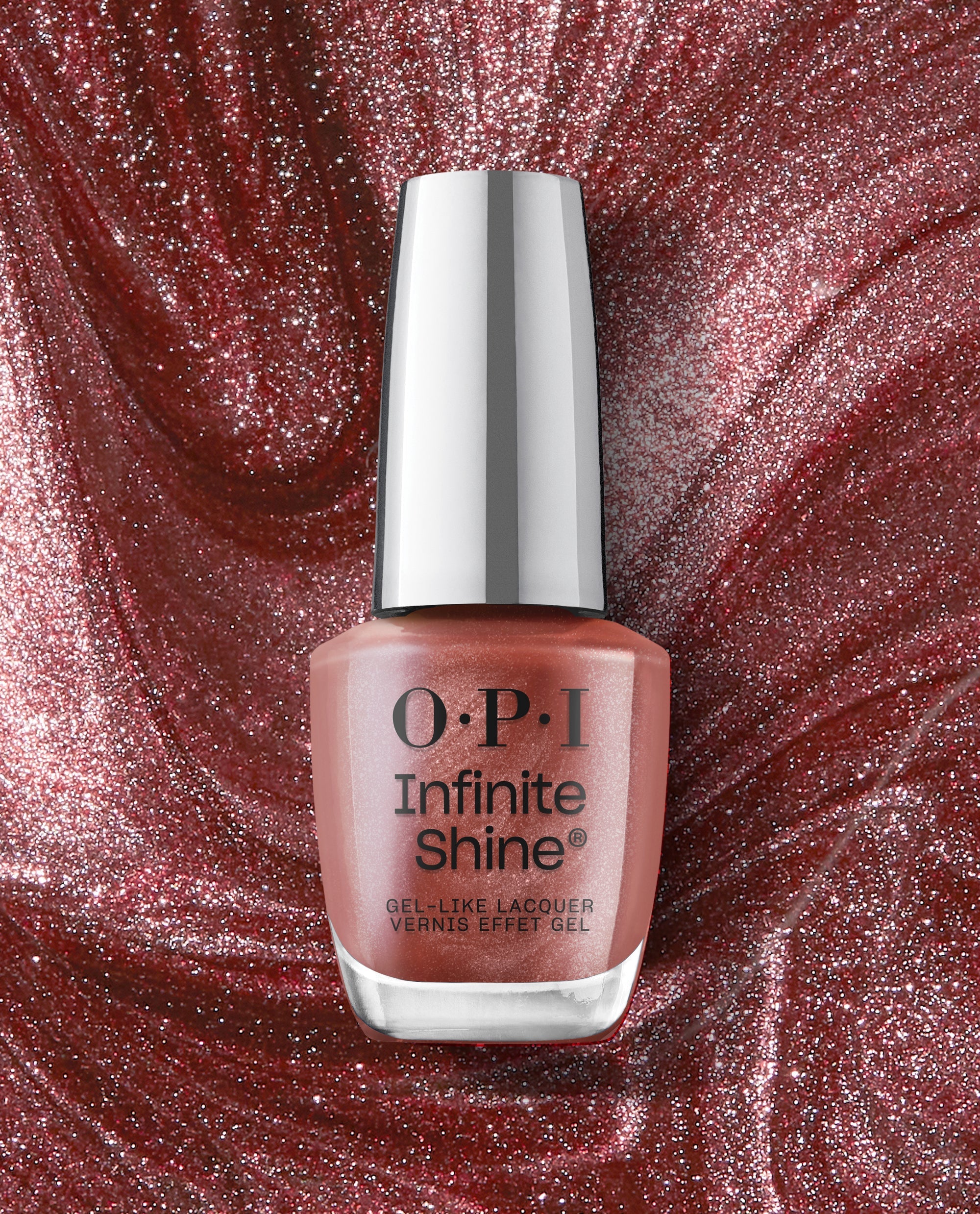 Stellar Tips OPI nail polish Infinite Shine bottle stands upright, showcasing its shimmery rose-gold gel-like lacquer against a swirling metallic red glitter background for a glamorous long-lasting manicure look.