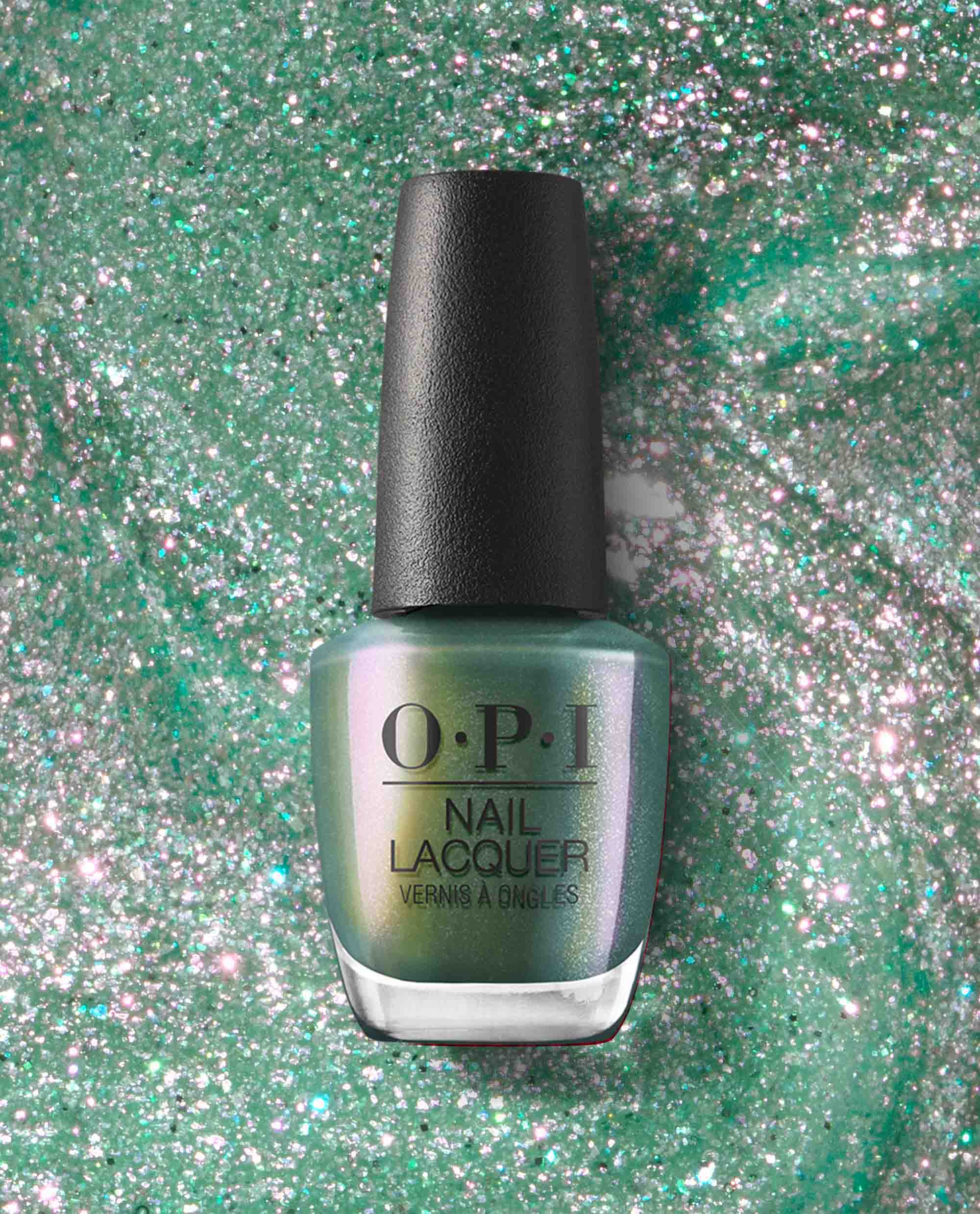 OPI Feelin’ Capricorn-y Nail Lacquer bottle showcasing iridescent green nail polish with fine glitter, centered on a swirled sparkly emerald backdrop—a fresh, shimmery choice for spring nail colors from OPI.