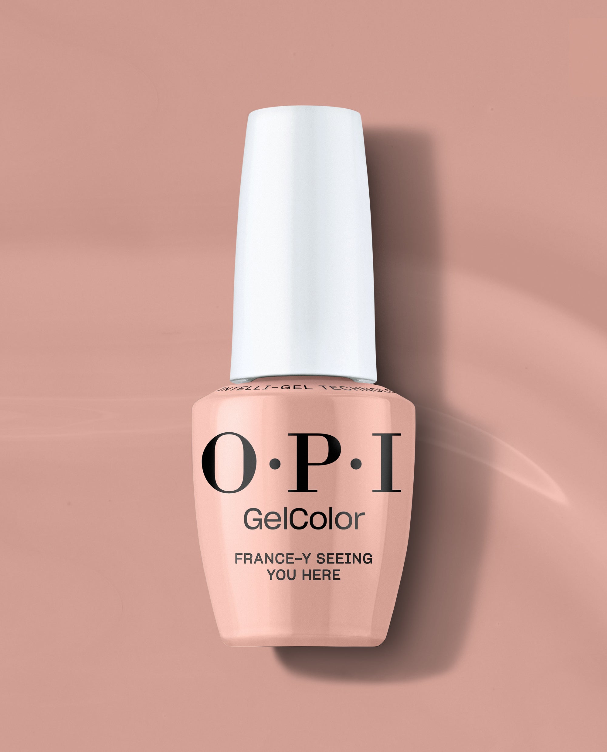 OPI GelColor France-y Seeing You Here gel nail polish in a soft peachy nude shade stands upright with a white cap on a blush pink background, ideal for subtle fall nail colors.