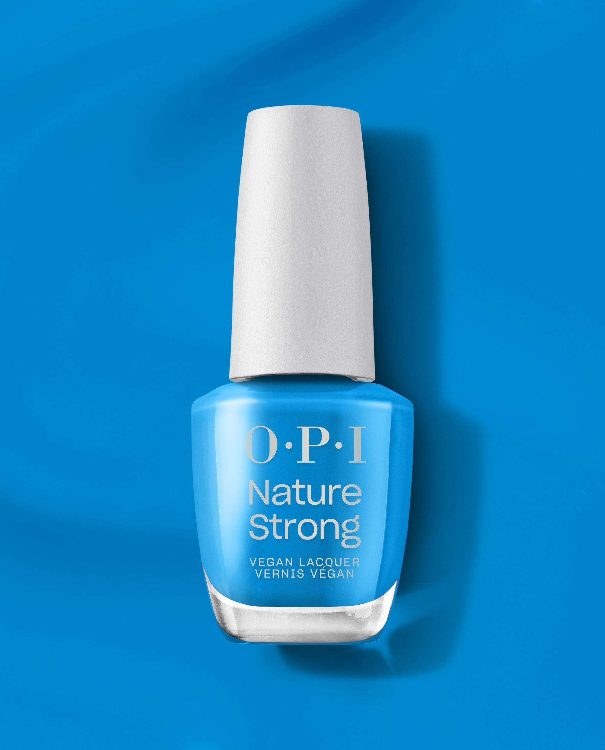 OPI Fresh as a Blue Daisy Nature Strong vegan nail lacquer bottle stands upright, showing bright sky-blue polish, a white cap, and silver logo against a matching blue background.