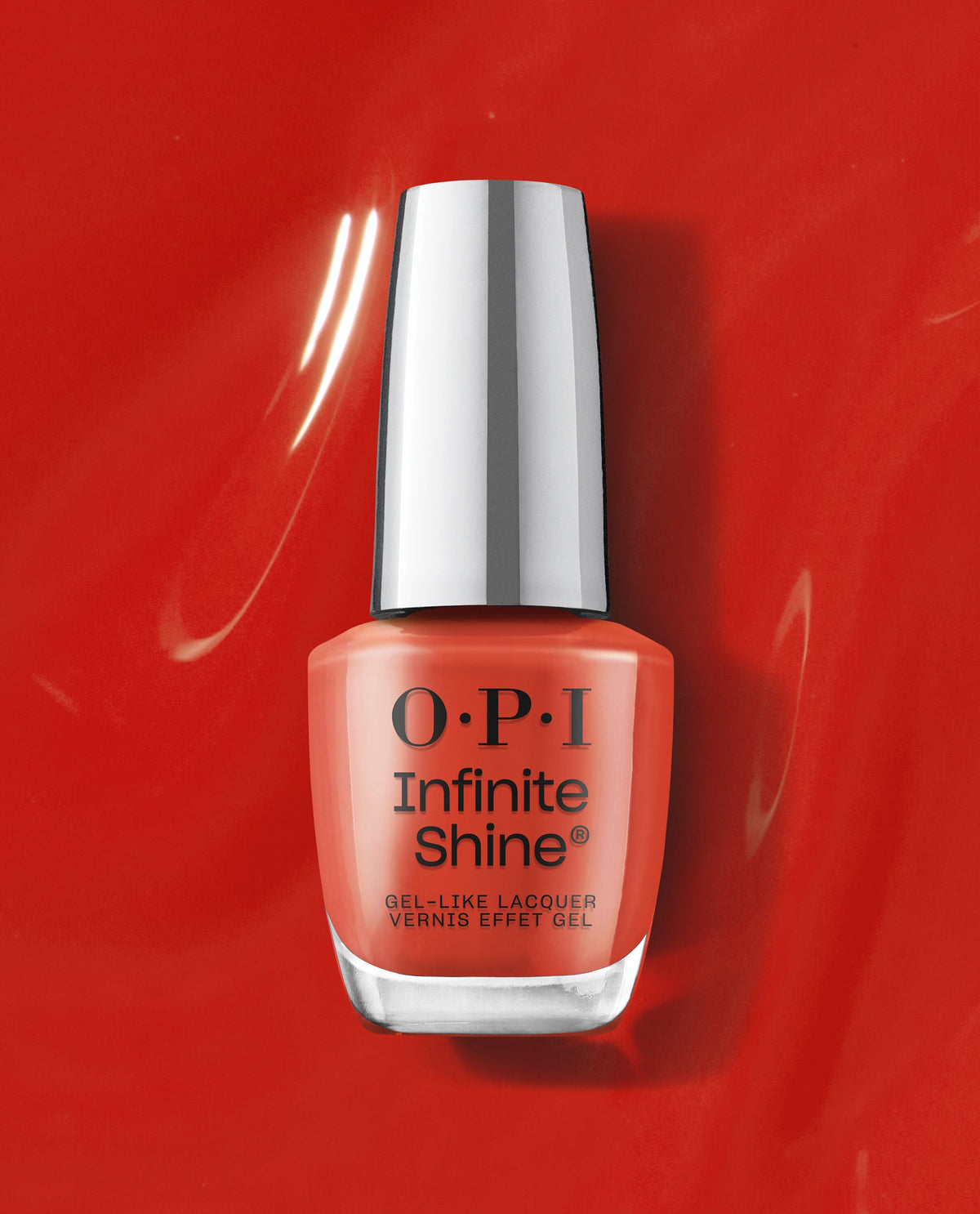 OPI Infinite Shine Full of Glambition coral-orange gel-like lacquer bottle standing on a glossy red polish background, a vibrant pick for fall nail colors.