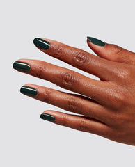 Manicured hand displaying deep forest green, glossy nails coated with Garden My French At-Home Gel Nail Polish, a chic green nail polish ideal for spring nail colors, shown on a neutral gray background; perfect for fans of OPI shades.