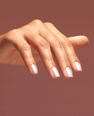 Hand gracefully posed to showcase nails painted in Gemini and I nail lacquer, a soft shimmering pearl shade of OPI nail polish, against a warm rose-brown background for a modern, elegant manicure look.