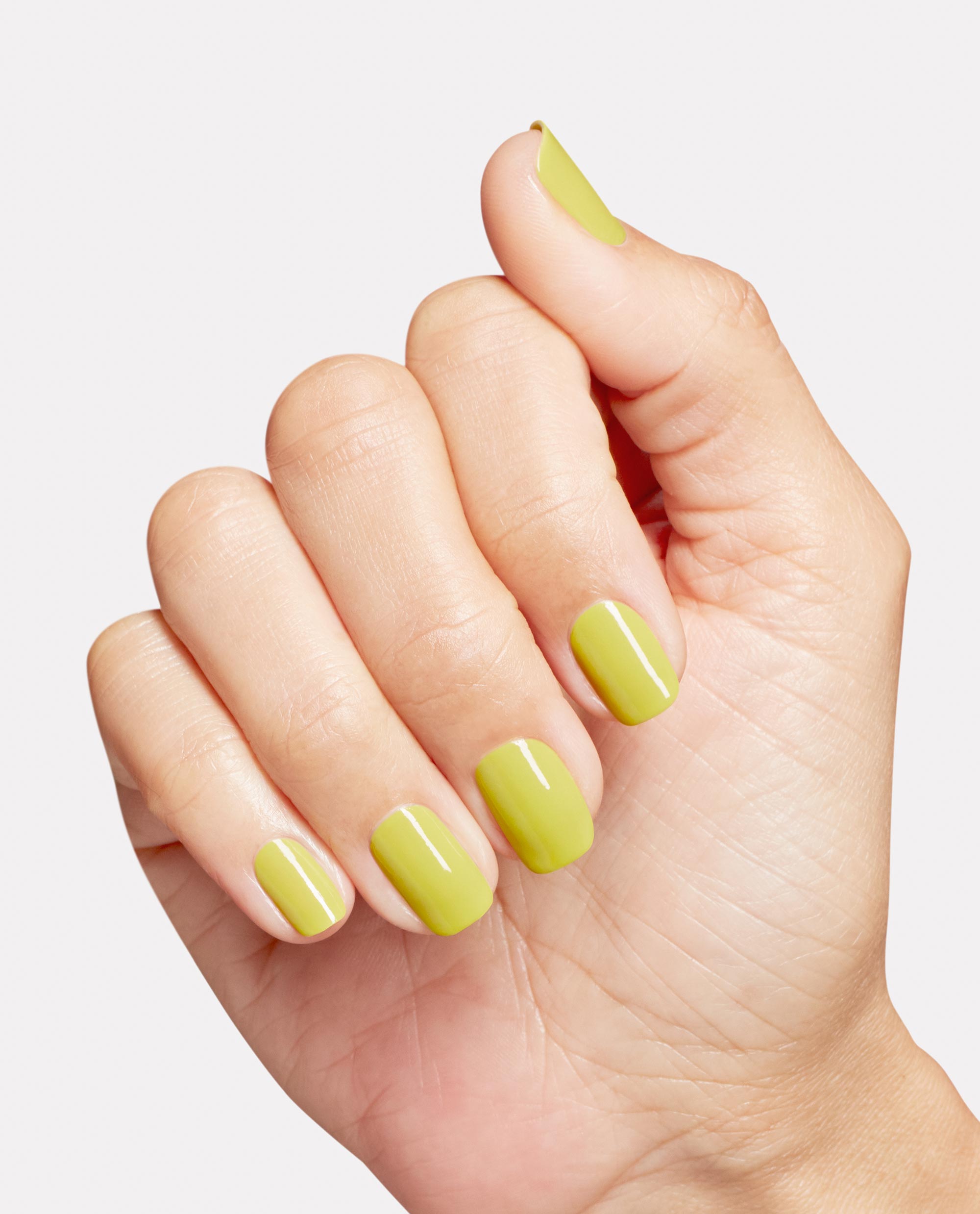 Manicured hand showcasing glossy lime-green nails painted with Give Me Some Suga Cane, OPI Nature Strong Vegan Nail Lacquer—a fresh green nail polish ideal for spring nail colors—shown in a studio close-up on a clean white background.