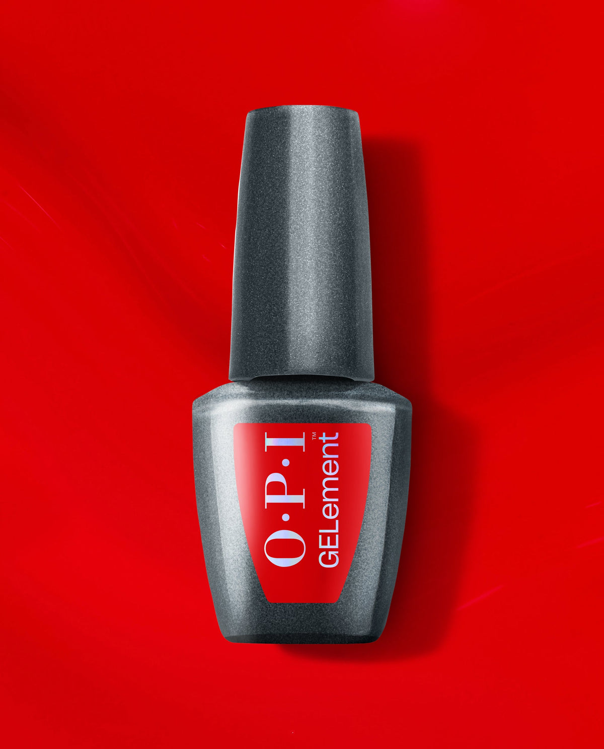 OPI Glossy Goddess at-home gel nail polish bottle in shimmering gunmetal gray stands upright on a vivid red background, a bold metallic shade for fall nail colors.