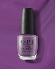 OPI nail polish bottle, shade Grandma Kissed a Gaucho, stands upright showing creamy medium purple nail lacquer against a matching rich violet background, highlighting the salon-quality OPI Nail Lacquer product for manicures and pedicures.