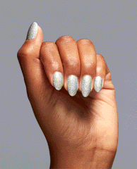 Hand with medium skin tone flexing to showcase I Cancer-tainly Shine OPI nail polish, a holographic silver glitter nail lacquer sparkling under light against a plain gray background, highlighting full, even coverage and glossy finish.