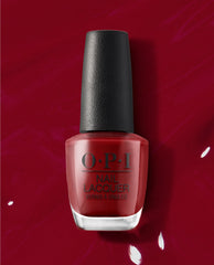 OPI nail polish bottle of I Love You Just Be-Cusco nail lacquer standing upright, showcasing a rich deep red shade against a glossy matching red polish background, highlighting the premium salon-quality manicure color for US shoppers.