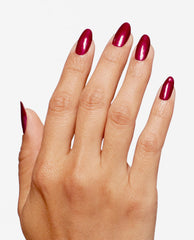 Hand displays almond-shaped nails painted in OPI Infinite Shine I'm Not Really a Waitress, a glossy deep red shimmer shade ideal for fall nail colors, on a clean white background.