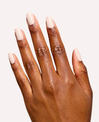 Hand modeling OPI Infinite Shine in I’m the Bossa Nova Now, a glossy pale beige fall nail color on short square nails against a clean white studio background.