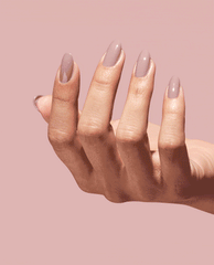 Hand modeling glossy taupe-mauve OPI Kind of a Twig Deal Nature Strong Vegan Nail Lacquer on almond-shaped nails against a soft pink background, a subtle choice for fall nail colors.