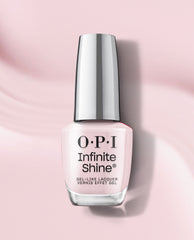 OPI Infinite Shine Lavender Bath pale pink gel-like lacquer bottle stands upright on a soft pink background with a reflective silver cap and subtle shadow.